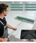 Hella Durable Paint Roller Kit With Adjustable Extension Pole And Non Shedding Rollers For Walls Ceilings Floors Includes Sturdy Deck Brush, man using roller on floor.