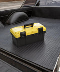 16 Inch Plastic Toolbox With Handle Portable Toolbox With Removable Tray And Lockable Design Built Tough For Home Workshop Or Garage With Small Parts Box In Black And Yellow, placed on a truck bed