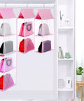 Space Saving Hanging Purse Organizer With Four Compartments For Closet Storage, showing handbags neatly stored in pink fabric.