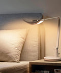 Eye Care Desk Lamp With Auto Dim, CRI 97, and adjustable color temperature in a bedroom setting, 51 inch wide illumination