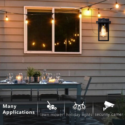 Black Outdoor Wall Mount Porch Light With Two Built In GFCI Outlets And Weatherproof Exterior Fixture by patio table at night