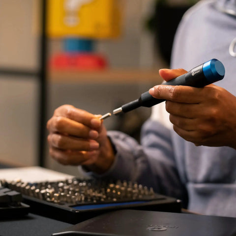 Person using Manta Driver Kit All In One Household PC Phone And Electronics Bit Set with premium knurled aluminum handle