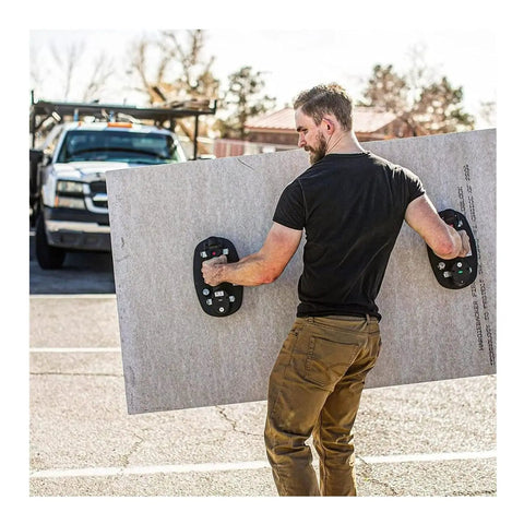 Man using Grabo Nemo Electric Vacuum Suction Cup Lifter to carry large stone panel effortlessly outdoors.