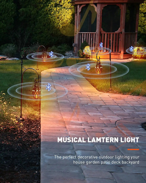 2 Pack Outdoor Bluetooth Speakers With LED Flame Flickers lining a garden path, providing a warm ambiance with wireless stereo sound.