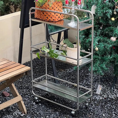 Slick Rolling Kitchen Island Trolley With Ample Storage Shelves And Quiet Locking Wheels For Mobile Coffee Bar Station Or Heavy Duty Stainless Steel Tool Caddy Rig in outdoor setting with plants.