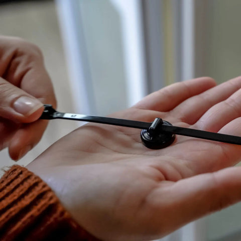 Magnetic Cable Zip Tie Mounts Black 20 Pack With 20 Black Zip Ties Included being held in hand