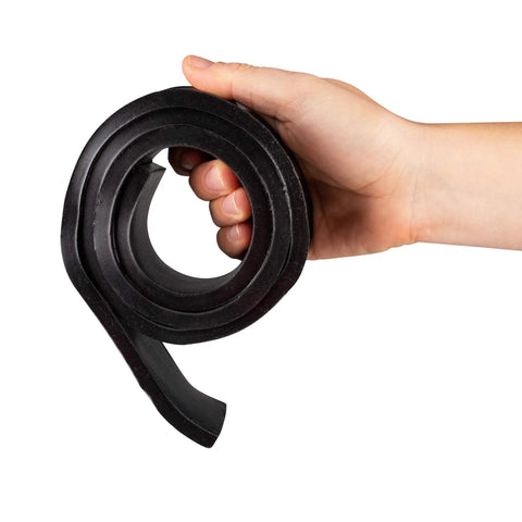 Hand holding coiled Beefed Up Heavy Duty Vibration Damping Rubber Strip 50 Duro 36 Inch By 2 Inch By One Eighth Inch Black Made In USA