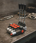 Heavy Duty Manual Hydraulic Directional Control Valve Block Featuring A Rock Solid Cast Iron Housing And Comfortable Lever Actuator for tractor gear on workshop table.