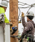 Utility workers using Six In One Lineman's Ratcheting Wrench With Bolt Through Design And Bright Yellow Socket on pole hardware.