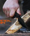 Hand using tactical knife with 3.5-inch blade on wood, part of All-In-One 175-Piece Survival Kit With First Aid for Outdoor Adventures and Emergencies.
