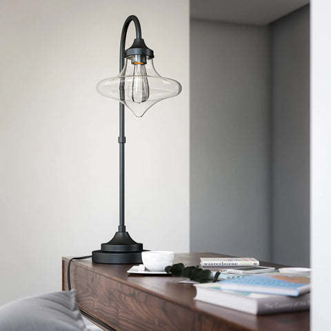 Rain Drop Table Lamp With Dope Glass Shade In Warm Bronze Finish, Mid Century Modern Rustic Style on a wooden surface next to books.