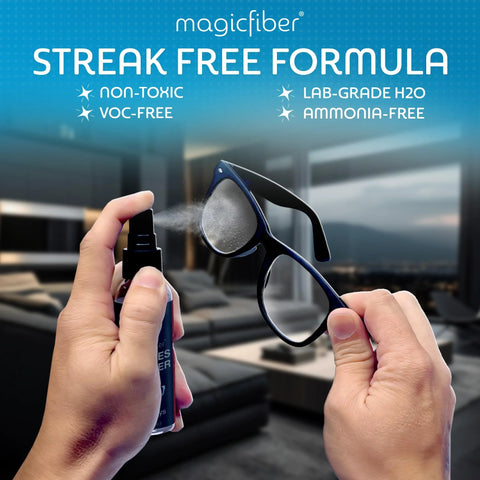 Front view of MagicFiber glasses cleaner kit: blue spray bottle spraying on black-rimmed eyeglasses.