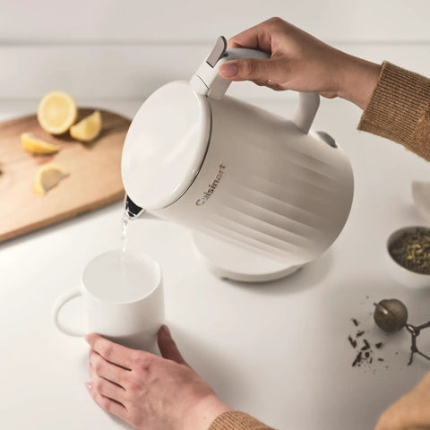 Person pouring water from Soho 1-Liter Double Wall Electric Kettle With Stainless Steel Interior One-Touch Boil into white mug
