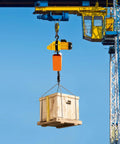 Heavy Duty 2200 Lbs Electric Chain Hoist With Single Phase Power Pulling Loads High Up To 10 Feet Fast And Smooth Overhead Crane System lifting a wooden crate.