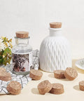 Conical Cork Bottle Stoppers Set For Wine And Beer 30 Pcs Wooden Plugs displayed with decorative bottles on a table