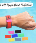 Wrist wearing a red wristband with a pink magic band protector, colorful magic band protectors displayed, blue background