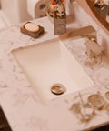 Rectangular Undermount White Porcelain Sink With Matte Black Drain Set And Overflow Pop Up Drain Sealer Included For Easy Install 1.75 Inch Drain Opening Inside Dimensions 11.5 By 16.25 By 6.5 Inches on marble countertop