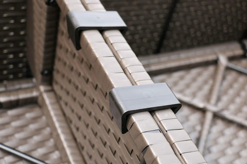 Close-up of high quality nylon clips securing modular sections of fire table set for outdoor sectional furniture with propane firepit dark brown rattan.