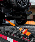 Ultimate Axle Tie Down Kit Pro Series Heavy Duty Webbing with ratchet strap securing vehicle on trailer
