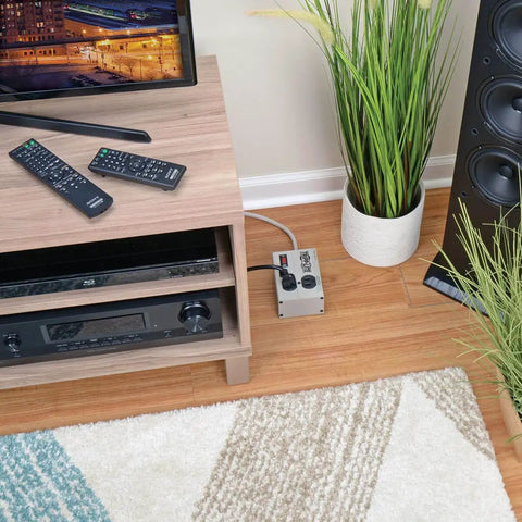 Isobar 2 Outlet Heavy Duty Power Strip Surge Protector With 1410 Joules 6ft Cord under wooden media console in living room