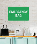 Emergency First Aid Sign For Outdoor Use 8 By 12 Inch Wall Decor in green aluminum on a brick wall above a kitchen counter.