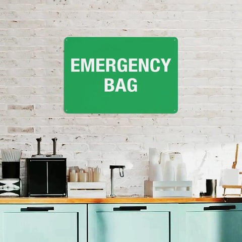 Emergency First Aid Sign For Outdoor Use 8 By 12 Inch Wall Decor in green aluminum on a brick wall above a kitchen counter.