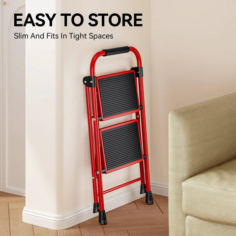 Red Two Step Folding Ladder With Wide Anti Slip Pedals And Handrails, compactly stored against wall, easy fold design