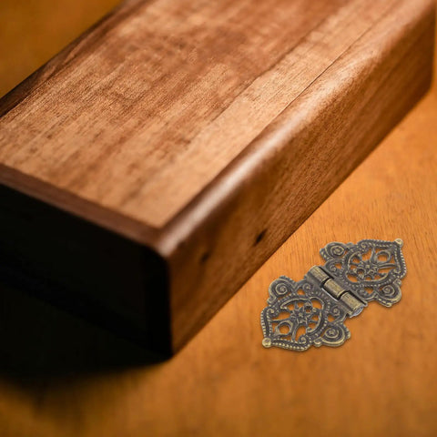 Close-up of 10 Piece Retro Bronze Zinc Alloy Hinges Set For Cabinets And Jewelry Boxes next to wooden box corner