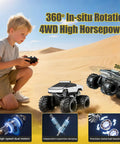 Child playing with Amphibious RC Car Scale 1 18 4WD All Terrain Off Road Pickup Beast With 2.4GHz Remote in a sandy desert