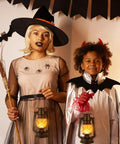 Two children dressed in Halloween costumes holding Outdoor Solar Lanterns With Flicker Flame LED, adding a warm glow.