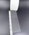 Fiberglass Drywall Repair Tape Self Adhesive Mesh, 2 Inch by 100 Ft Roll next to measuring tape, showing mesh size and texture