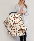 All In One Baby Car Seat Canopy And Nursing Cover with cowboy print, held by woman, breathable multi use shield for car seats