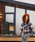 Portable Propane Radiant Heater With 18000 BTU For Warmth Up To 450 Sq Ft near a seated person outdoors