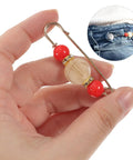 Hand holding a 12 Piece Heavy Duty Alloy Waist Adjustment Pin with decorative beads for securing baggy jeans.