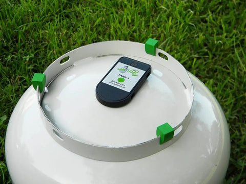 Propane Tank Gas Level Indicator With Bluetooth Magnetic Sensors mounted on LP tank in grassy area
