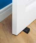 Four Pack Built Tough Heavy Duty Door Stoppers Zinc Alloy Wall Protector With Non Slip Surface Wedge holding a door open on wooden floor.