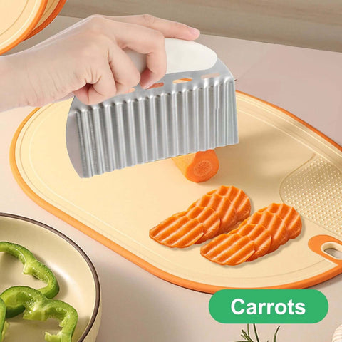 Stainless steel crinkle cutter with white handle, slicing carrots into wavy fries on a cutting board.