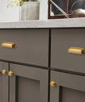 10 Pack 3 Inch Antique Brass Cup Pulls With Aged Gold Finish installed on kitchen drawer, vintage brass hardware shown in use.