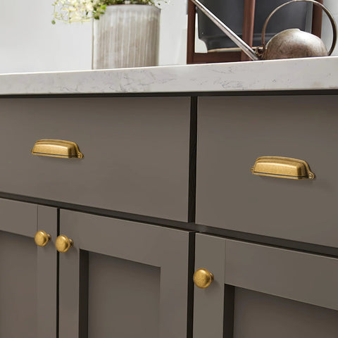 10 Pack 3 Inch Antique Brass Cup Pulls With Aged Gold Finish installed on kitchen drawer, vintage brass hardware shown in use.