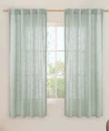63 Inch Light Sage Linen Curtains Set Of 2 Semi Sheer Panels With Back Tabs And Rod Pocket installed on a window