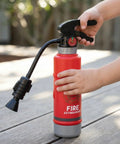 Realistic Water Squirt Fire Extinguisher Toy For Kids Pretend Play Durable Plastic being held by a child's hand outdoors.