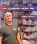 Image of a smiling man in a gray shirt standing in a warehouse with shelving behind him, promoting EDS Parts.