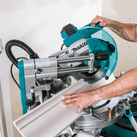 Makita LS1019L 10-inch dual-bevel sliding miter saw with laser; turquoise body, side view guiding wood stock