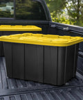 Six Pack Heavy Duty Stackable Industrial Totes Top Shelf Plastic Storage Bins With Secure Snap Lids Rock Solid Build For Garage Workshop And Warehouse Organization Black And Yellow in a truck bed.