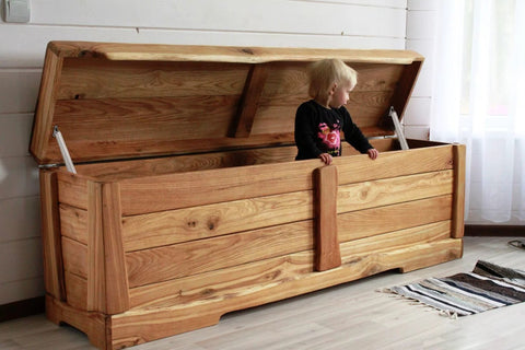 Wooden toy box chest with gas strut hinges; lid open, child standing inside.