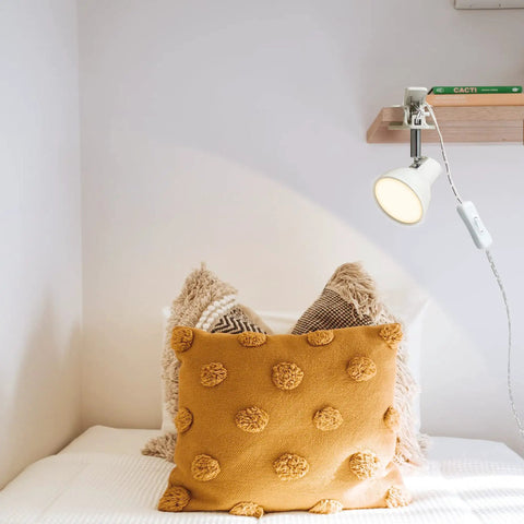 Lit Clip On LED Reading Light 5W 400LM with 330 Degree Rotation Clamp attached to a shelf illuminating a bed with pillows