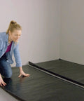 Woman installing 360 Sq Ft Flooring Underlayment For Luxury Vinyl Plank And Laminate on a flat surface.