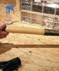 Applying Heavy Duty Waterproof Polyurethane Glue In Rich Brown to a wooden tool handle for a strong bond, showcasing effective use.