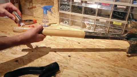 Applying Heavy Duty Waterproof Polyurethane Glue In Rich Brown to a wooden tool handle for a strong bond, showcasing effective use.