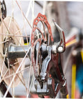 Complete Mechanical Disc Brake System For Mountain Bike Front And Rear With Forged Aluminum Calipers And Long Wear Pads That Give You Dang Serious Stopping Power On Gnarly Downhills Without Breaking The Bank, close-up of rear brake caliper and rotor.